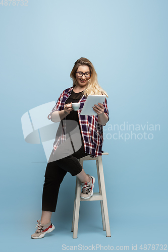 Image of Young caucasian woman in casual wear on blue background. Bodypositive female character, plus size businesswoman