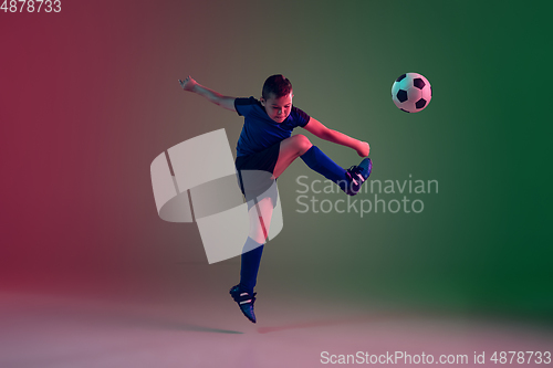 Image of Teen male football or soccer player, boy on gradient background in neon light - motion, action, activity concept