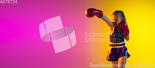 Image of Little caucasian female kick boxer training on gradient background in neon light, active and expressive