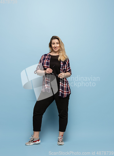 Image of Young caucasian woman in casual wear on blue background. Bodypositive female character, plus size businesswoman