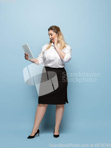 Image of Young caucasian woman in office attire on blue background. Bodypositive female character. plus size businesswoman