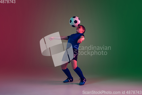 Image of Teen male football or soccer player, boy on gradient background in neon light - motion, action, activity concept