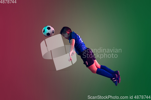 Image of Teen male football or soccer player, boy on gradient background in neon light - motion, action, activity concept