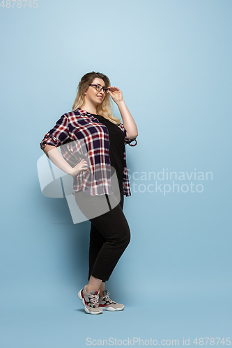 Image of Young caucasian woman in casual wear on blue background. Bodypositive female character, plus size businesswoman