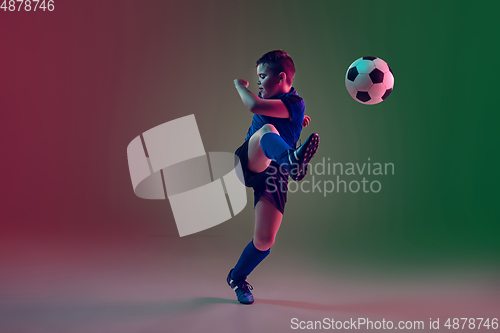 Image of Teen male football or soccer player, boy on gradient background in neon light - motion, action, activity concept