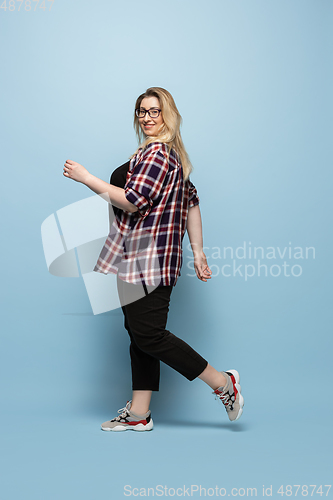 Image of Young caucasian woman in casual wear on blue background. Bodypositive female character, plus size businesswoman