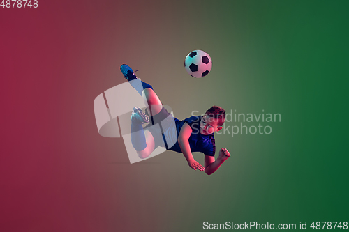 Image of Teen male football or soccer player, boy on gradient background in neon light - motion, action, activity concept