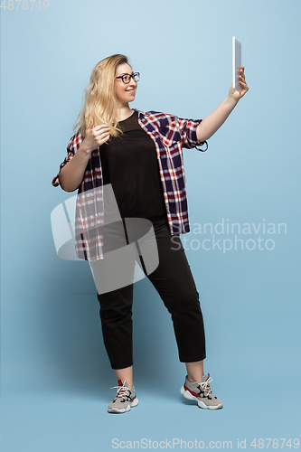 Image of Young caucasian woman in casual wear on blue background. Bodypositive female character, plus size businesswoman