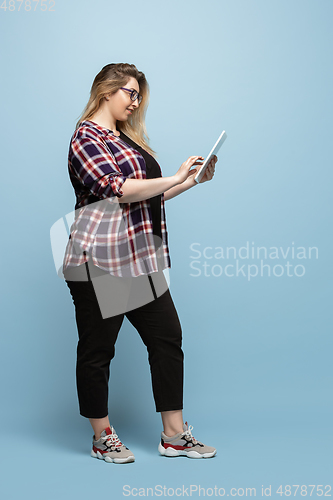 Image of Young caucasian woman in casual wear on blue background. Bodypositive female character, plus size businesswoman