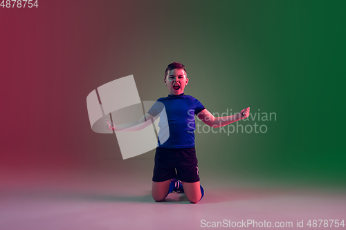 Image of Teen male football or soccer player, boy on gradient background in neon light - motion, action, activity concept