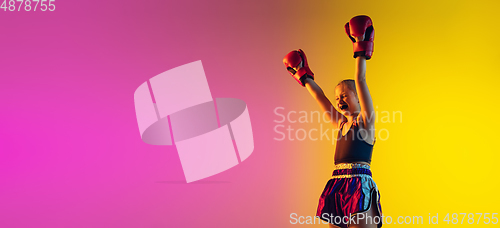 Image of Little caucasian female kick boxer training on gradient background in neon light, active and expressive