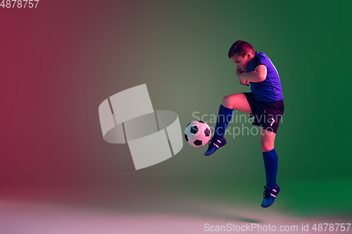 Image of Teen male football or soccer player, boy on gradient background in neon light - motion, action, activity concept