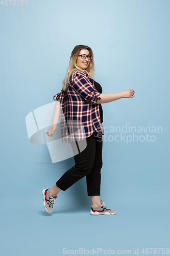 Image of Young caucasian woman in casual wear on blue background. Bodypositive female character, plus size businesswoman