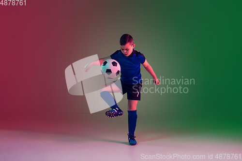 Image of Teen male football or soccer player, boy on gradient background in neon light - motion, action, activity concept