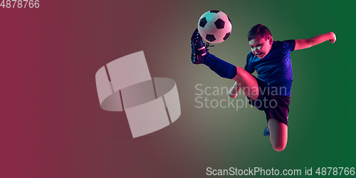 Image of Teen male football or soccer player, boy on gradient background in neon light - motion, action, activity concept