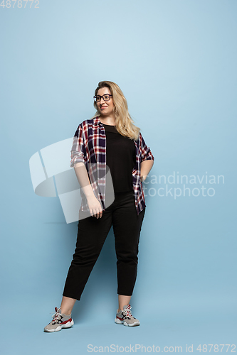 Image of Young caucasian woman in casual wear on blue background. Bodypositive female character, plus size businesswoman