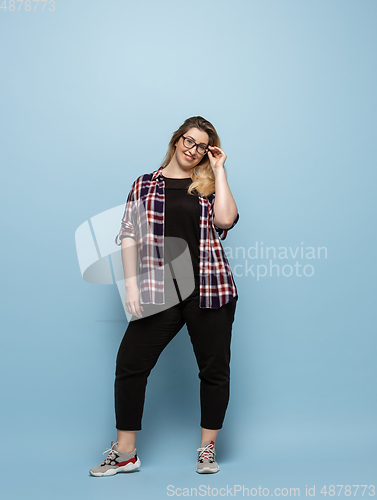 Image of Young caucasian woman in casual wear on blue background. Bodypositive female character, plus size businesswoman