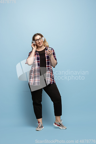 Image of Young caucasian woman in casual wear on blue background. Bodypositive female character, plus size businesswoman