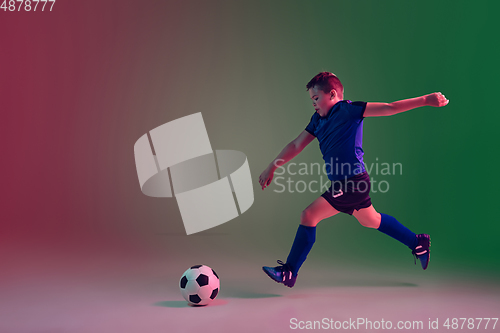Image of Teen male football or soccer player, boy on gradient background in neon light - motion, action, activity concept