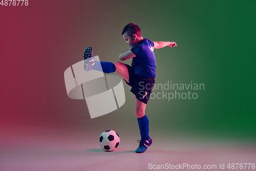 Image of Teen male football or soccer player, boy on gradient background in neon light - motion, action, activity concept