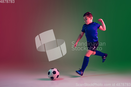 Image of Teen male football or soccer player, boy on gradient background in neon light - motion, action, activity concept