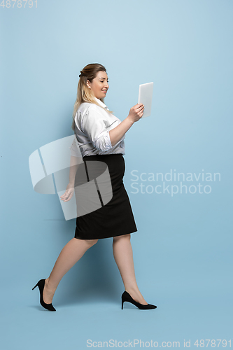 Image of Young caucasian woman in office attire on blue background. Bodypositive female character. plus size businesswoman