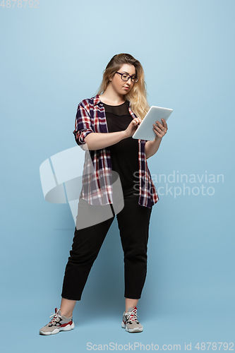 Image of Young caucasian woman in casual wear on blue background. Bodypositive female character, plus size businesswoman