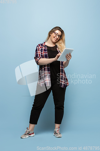 Image of Young caucasian woman in casual wear on blue background. Bodypositive female character, plus size businesswoman