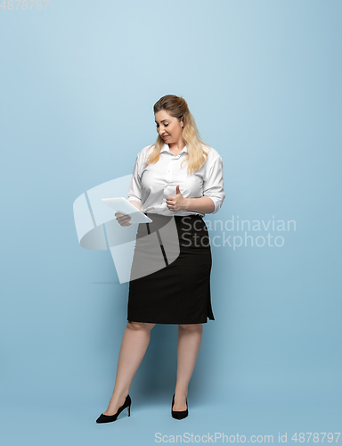 Image of Young caucasian woman in office attire on blue background. Bodypositive female character. plus size businesswoman