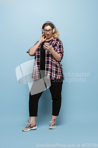 Image of Young caucasian woman in casual wear on blue background. Bodypositive female character, plus size businesswoman