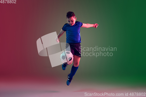 Image of Teen male football or soccer player, boy on gradient background in neon light - motion, action, activity concept