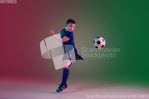 Image of Teen male football or soccer player, boy on gradient background in neon light - motion, action, activity concept