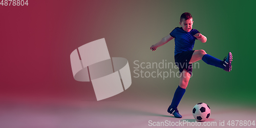 Image of Teen male football or soccer player, boy on gradient background in neon light - motion, action, activity concept