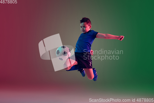 Image of Teen male football or soccer player, boy on gradient background in neon light - motion, action, activity concept