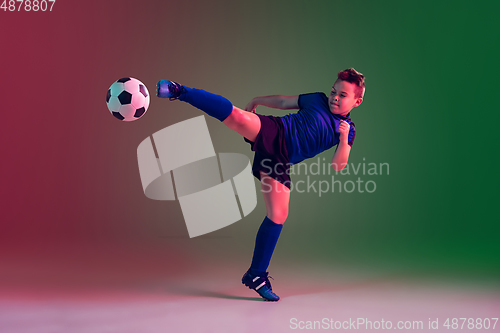 Image of Teen male football or soccer player, boy on gradient background in neon light - motion, action, activity concept