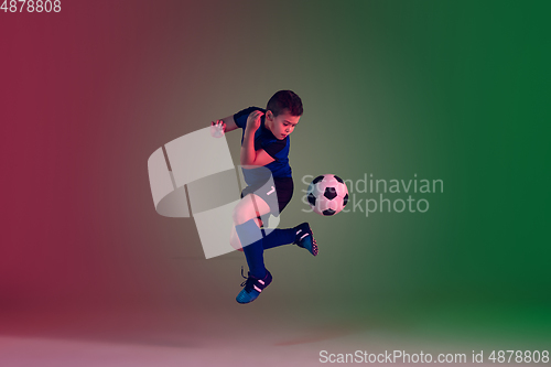 Image of Teen male football or soccer player, boy on gradient background in neon light - motion, action, activity concept