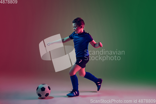 Image of Teen male football or soccer player, boy on gradient background in neon light - motion, action, activity concept