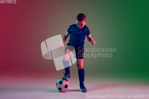 Image of Teen male football or soccer player, boy on gradient background in neon light - motion, action, activity concept