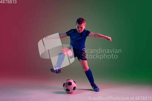 Image of Teen male football or soccer player, boy on gradient background in neon light - motion, action, activity concept