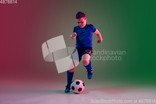 Image of Teen male football or soccer player, boy on gradient background in neon light - motion, action, activity concept