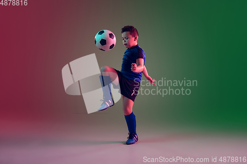 Image of Teen male football or soccer player, boy on gradient background in neon light - motion, action, activity concept