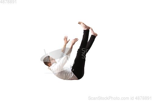 Image of Mid-air beauty. Full length studio shot of attractive young man hovering in air and keeping eyes closed