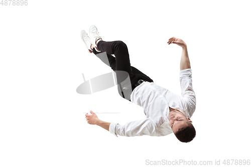 Image of Mid-air beauty. Full length studio shot of attractive young man hovering in air and keeping eyes closed