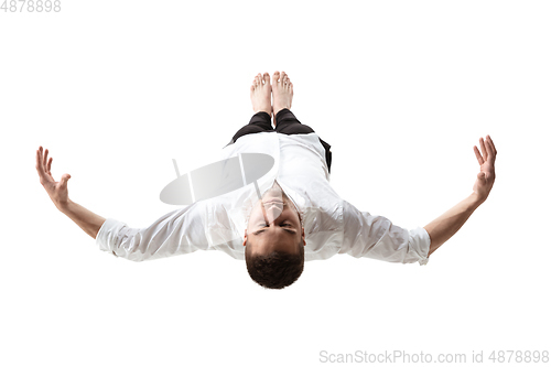 Image of Mid-air beauty. Full length studio shot of attractive young man hovering in air and keeping eyes closed