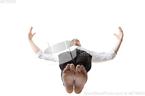 Image of Mid-air beauty. Full length studio shot of attractive young man hovering in air and keeping eyes closed