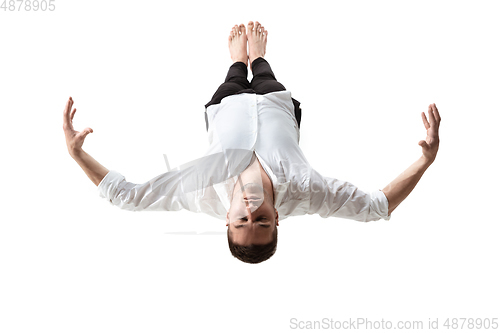 Image of Mid-air beauty. Full length studio shot of attractive young man hovering in air and keeping eyes closed