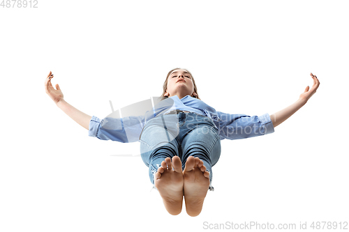 Image of Mid-air beauty. Full length studio shot of attractive young woman hovering in air and keeping eyes closed