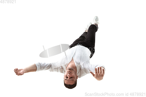 Image of Mid-air beauty. Full length studio shot of attractive young man hovering in air and keeping eyes closed