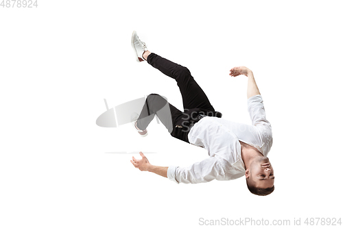 Image of Mid-air beauty. Full length studio shot of attractive young man hovering in air and keeping eyes closed