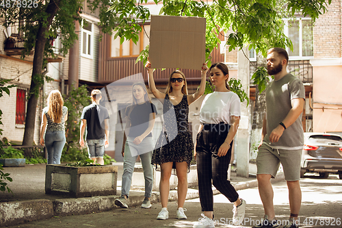 Image of Dude with sign - woman stands protesting things that annoy her